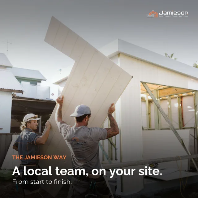 Two builders carrying a sheet of cladding on site. Card text: A local team, on your site. From start to finish.